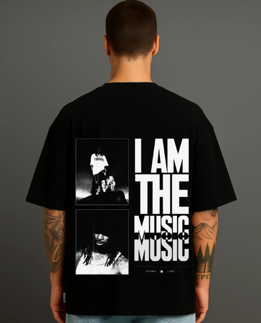 Man wearing Atraye black streetwear T-shirt with bold 'I AM THE MUSIC' graphic and musician photos.