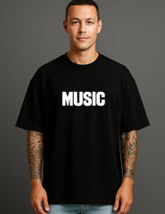 Man wearing ATRAYE black streetwear T-shirt with bold 'MUSIC' print, celebrating individuality.