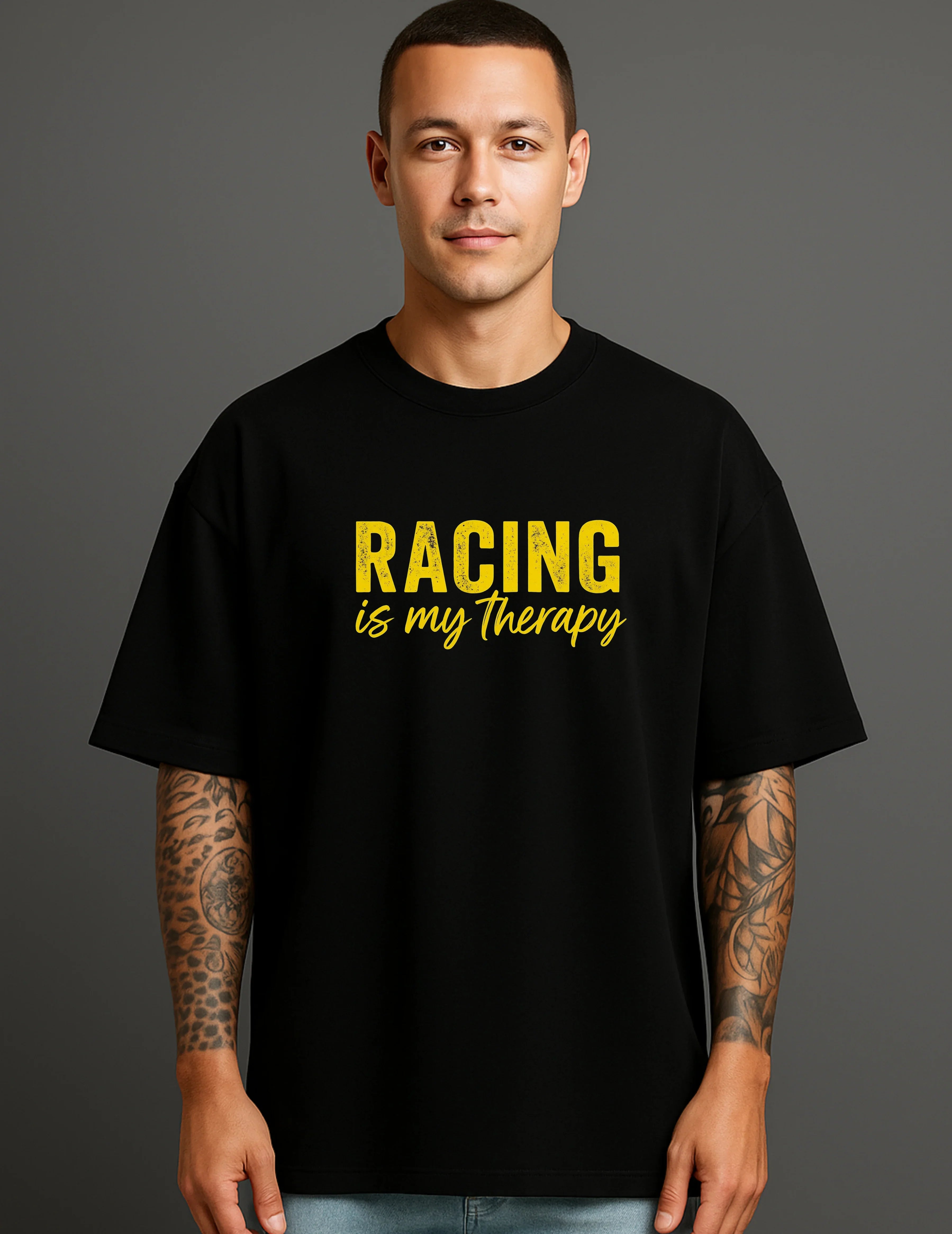 Man wearing a black ATRAYE streetwear T-shirt with yellow 'Racing is my therapy' print.