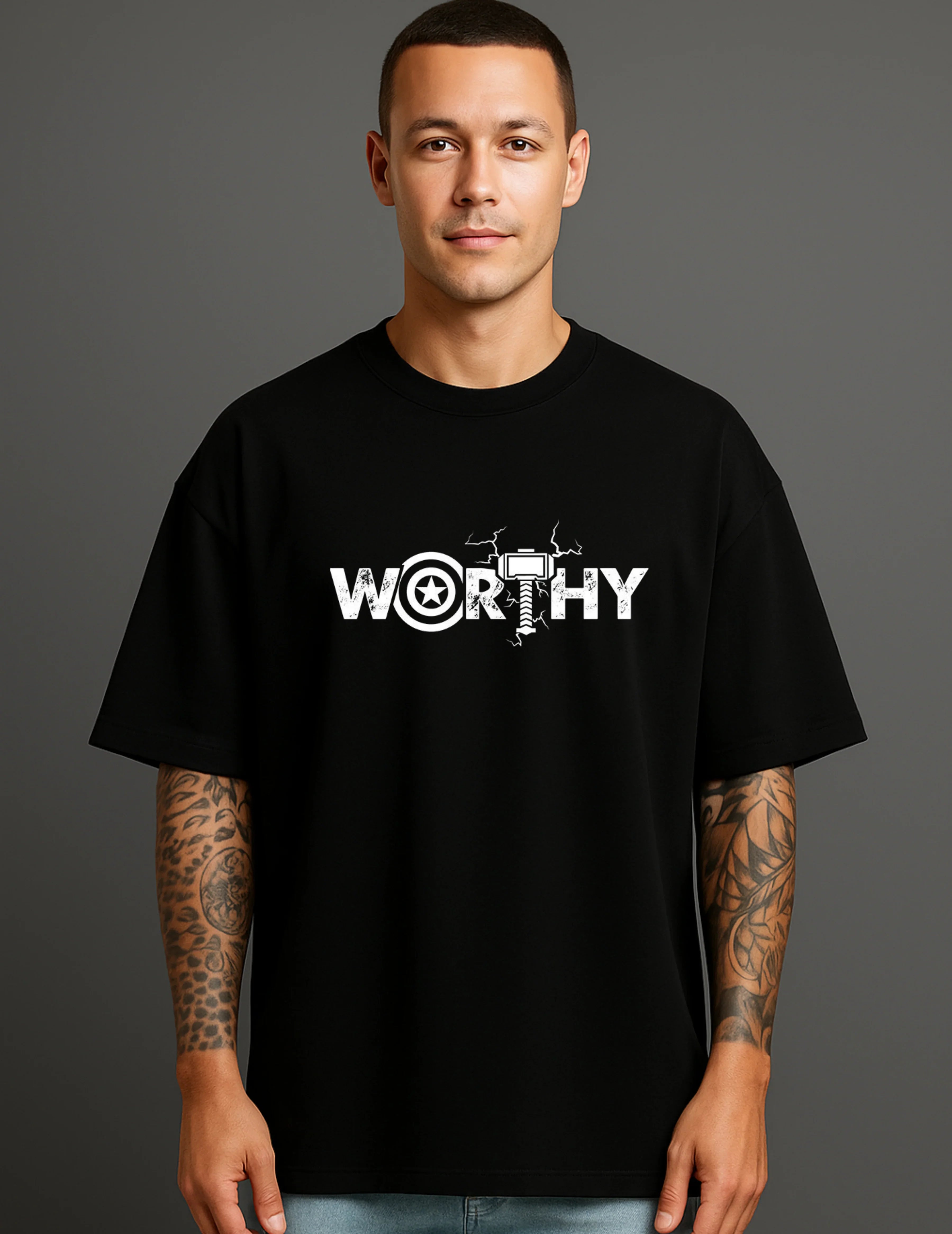 Man in black ATRAYE streetwear T-shirt with bold 'WORTHY' graphic and tattooed arms