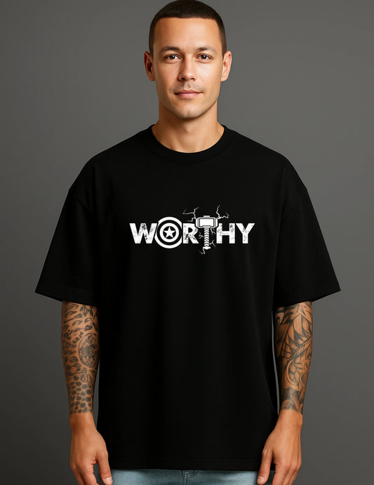 Man in black ATRAYE streetwear T-shirt with bold 'WORTHY' graphic and tattooed arms