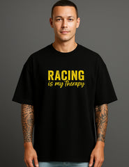 Man wearing a black ATRAYE streetwear T-shirt with yellow 'Racing is my therapy' print.