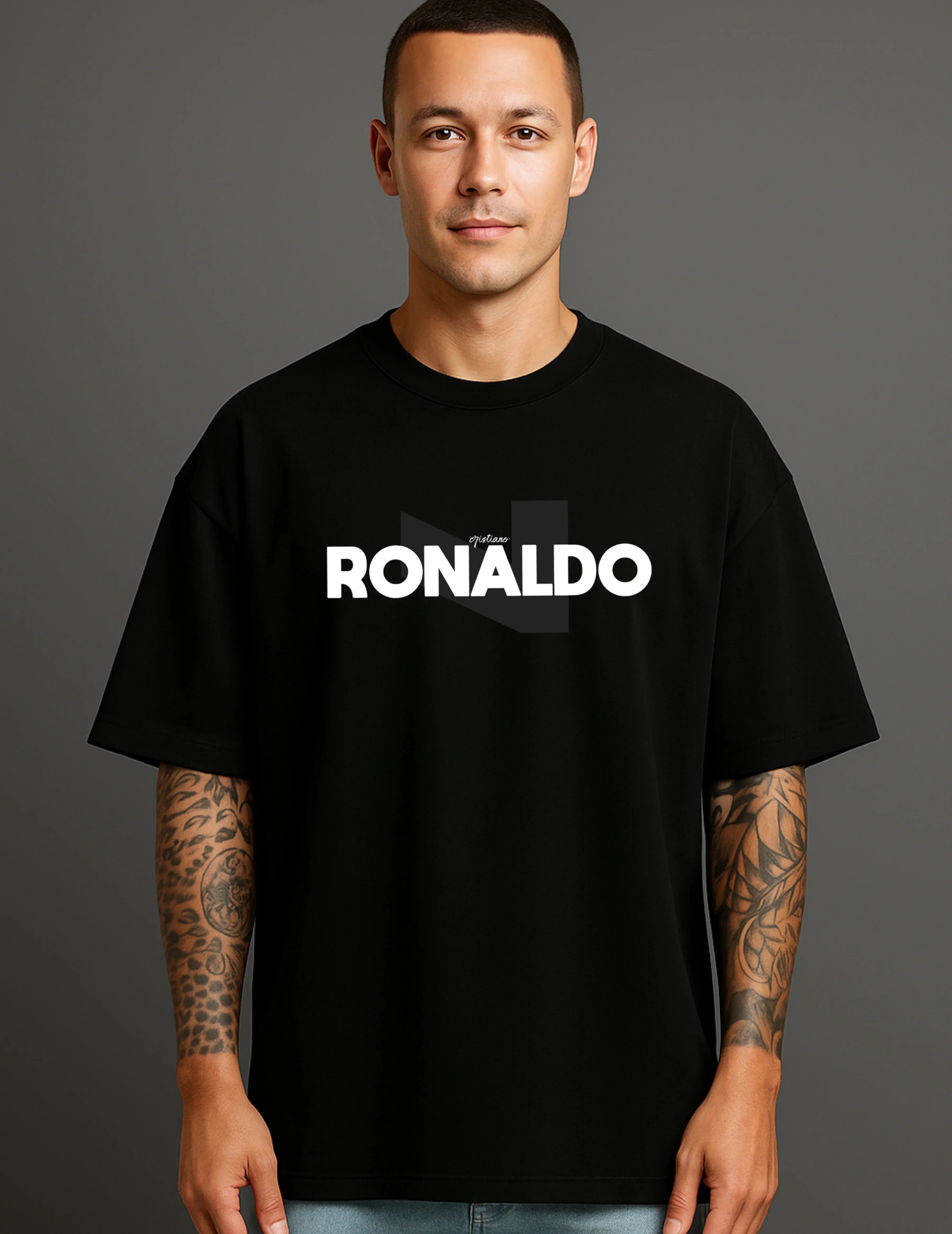 Man wearing a black ATRAYE streetwear T-shirt with bold 'RONALDO' print, tattooed arms visible.