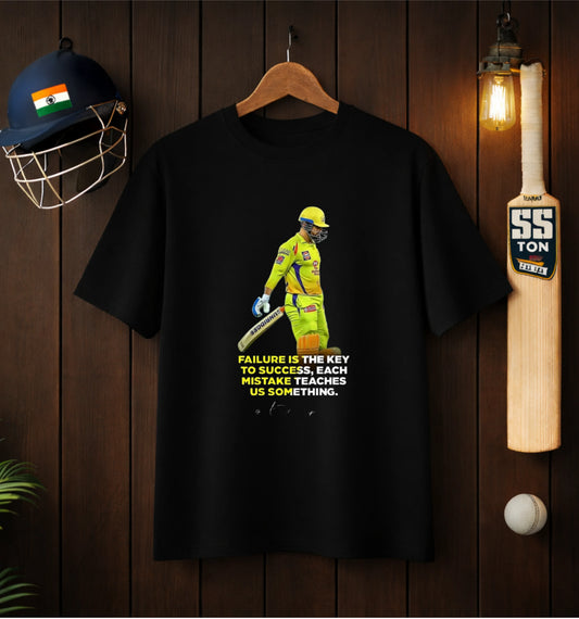 Black ATRAYE streetwear T-shirt with cricket player print and motivational quote, surrounded by helmet, bat, and ball.
