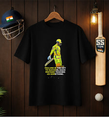 Black ATRAYE streetwear T-shirt with cricket player print and motivational quote, surrounded by helmet, bat, and ball.